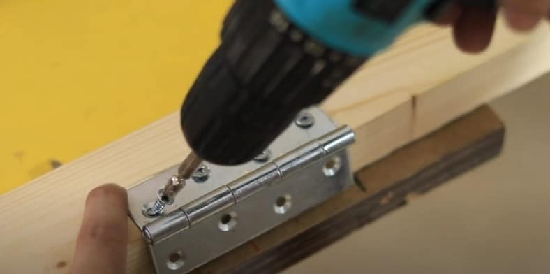 Install door hinge into position with an electric drill and screws