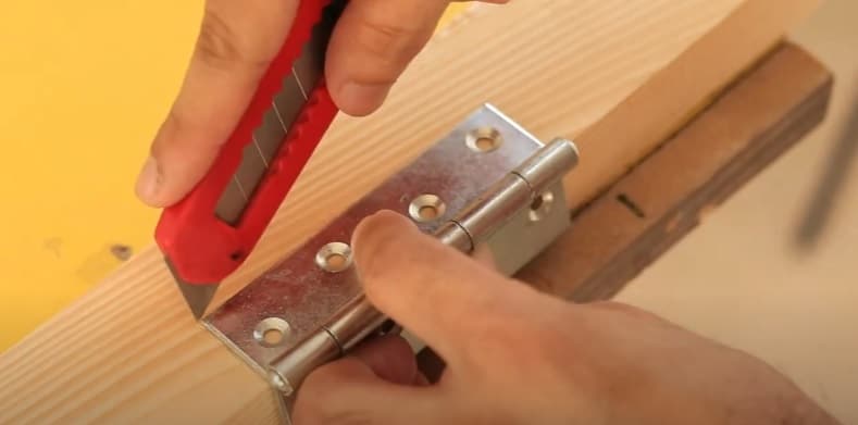 Outline the width and length of door hinge with pen knife