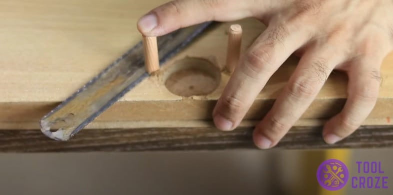 Remove excess wood dowel pins with hacksaw