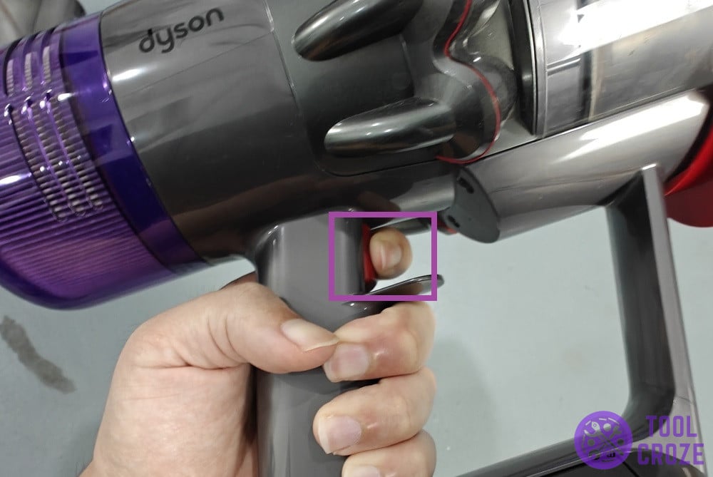 pressing the trigger on a dyson v11