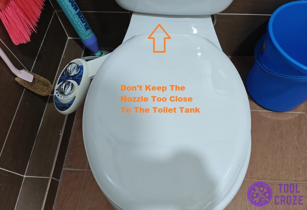 nozzle too close to toilet tank
