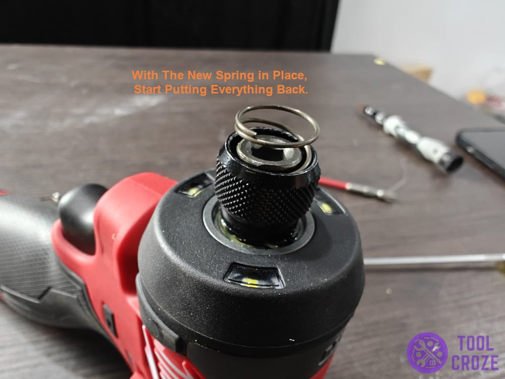 With the new spring in place, start putting everything back.