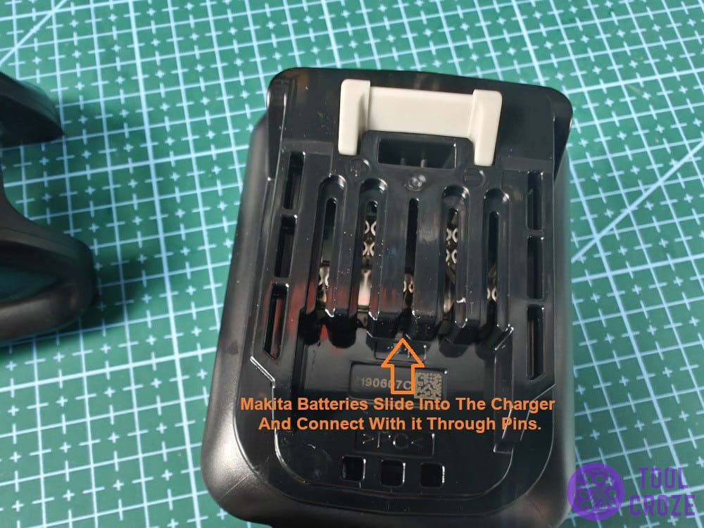 Makita batteries slide into the charger and connect with it through pins.