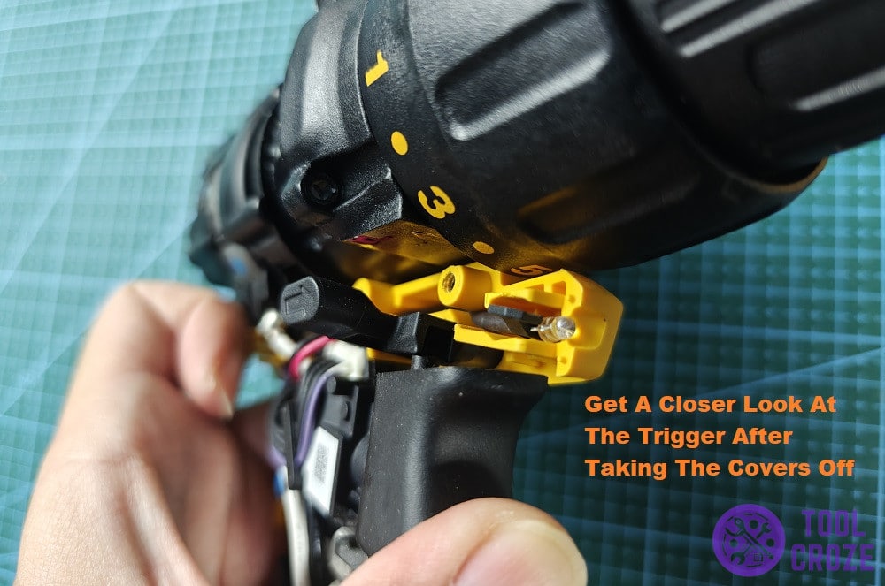 pressing down on exposed dewalt drill trigger