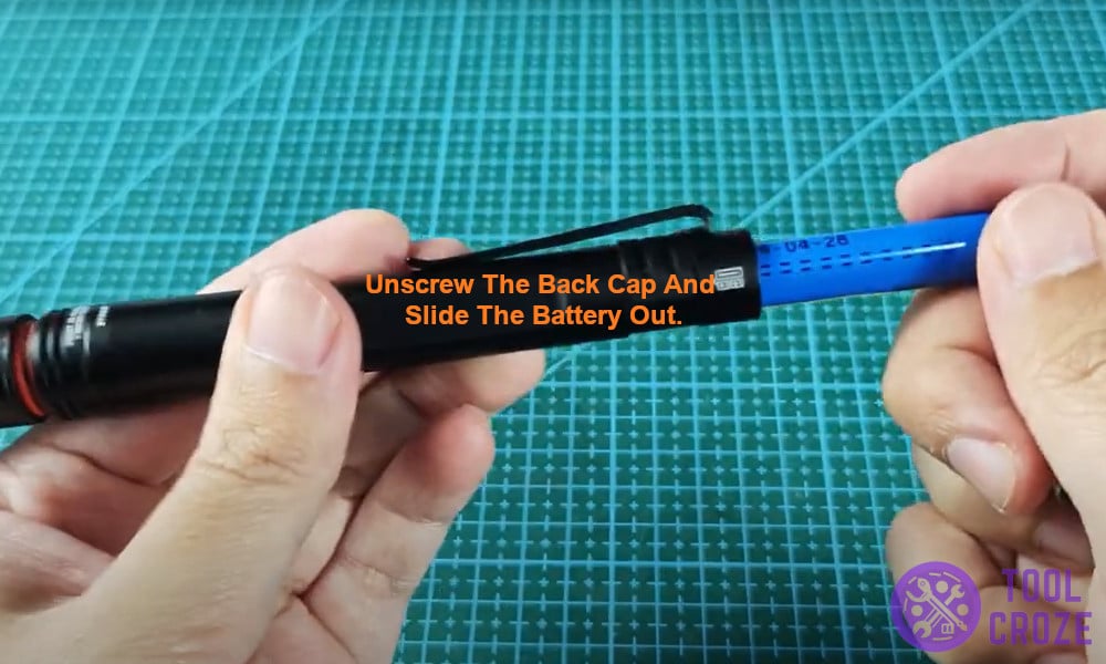 Unscrew the back cap and slide the battery out.