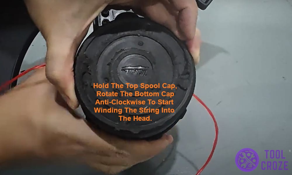 Hold the top spool cap.