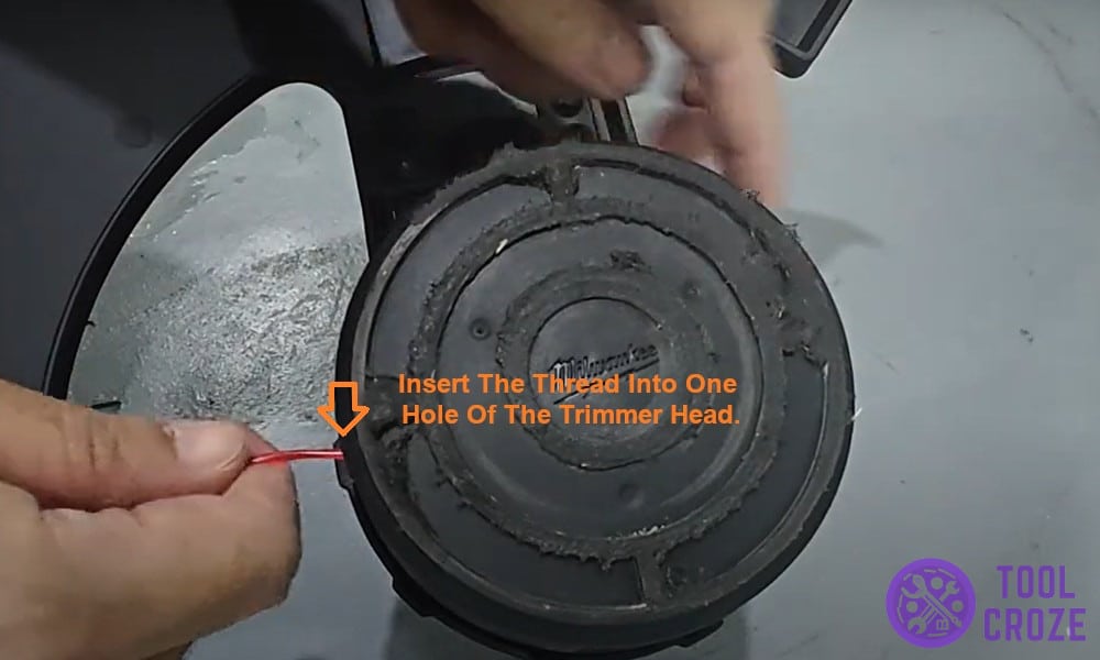 insert the thread into one hole of the trimmer head.