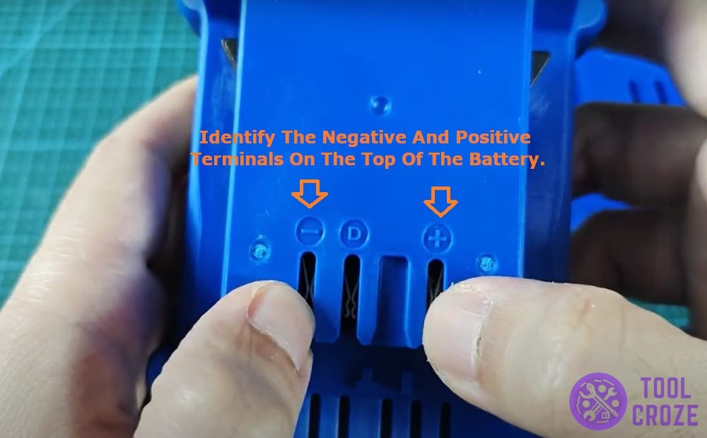 identify the negative and positive terminals on the top of the battery