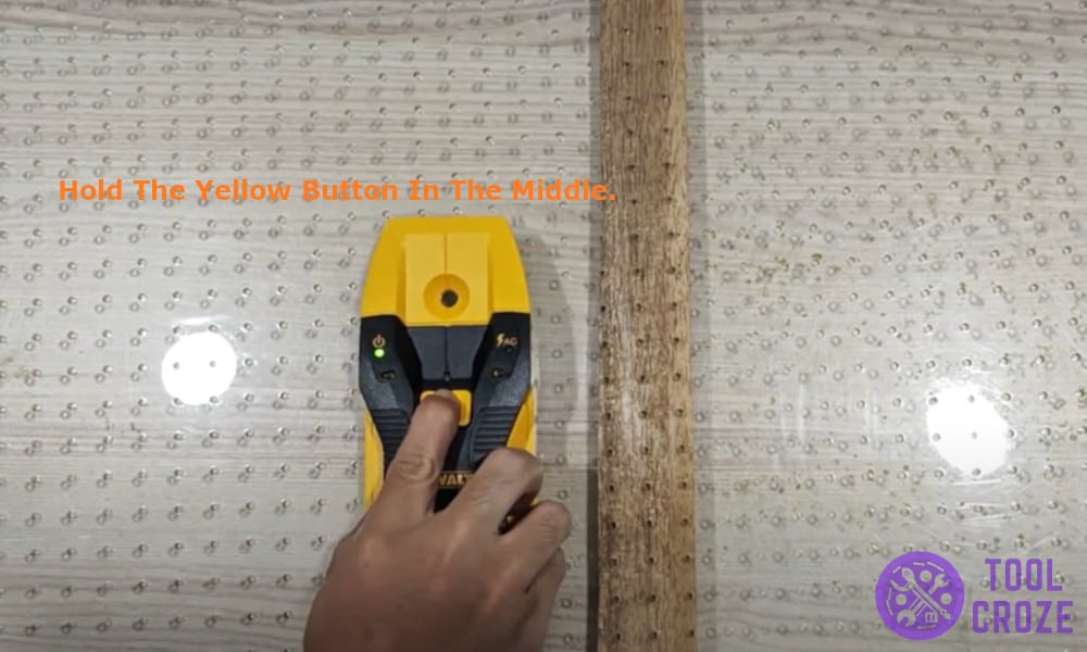 Hold the yellow button in the middle