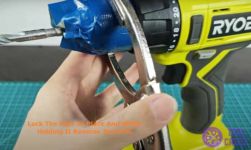 Lock the plier in place and while holding it reverse the drill.