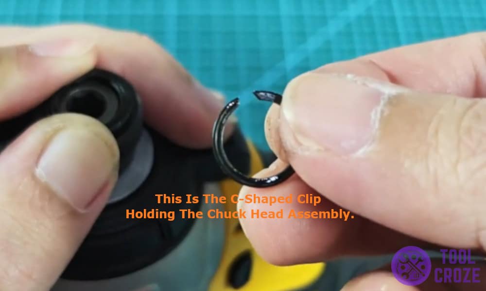 C-shaped clip holding the chuck head assembly.