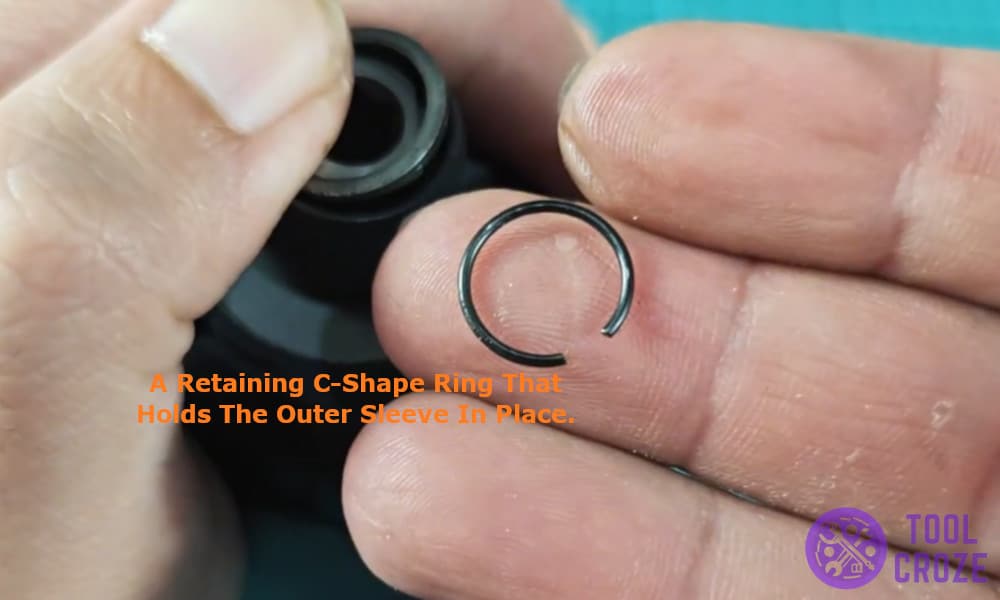a retaining C-shape ring that holds the outer sleeve in place.