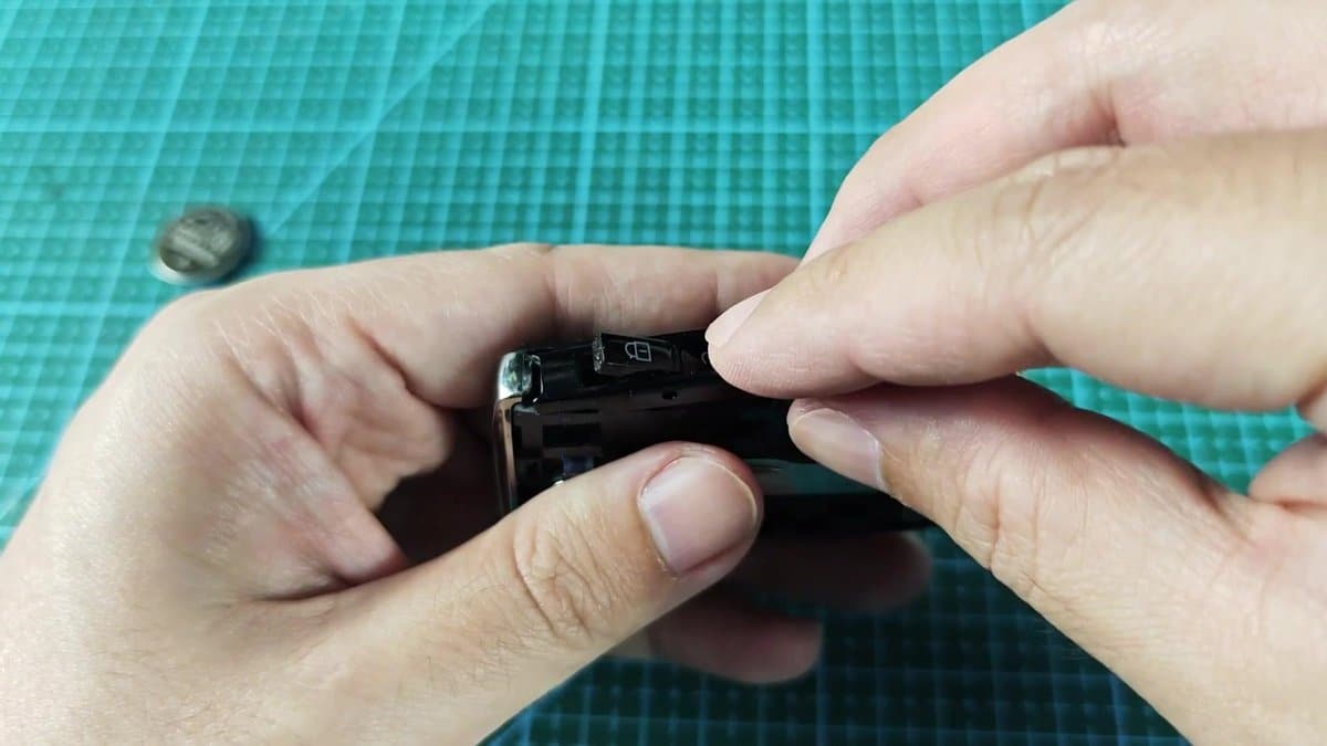 Button on black device being pressed