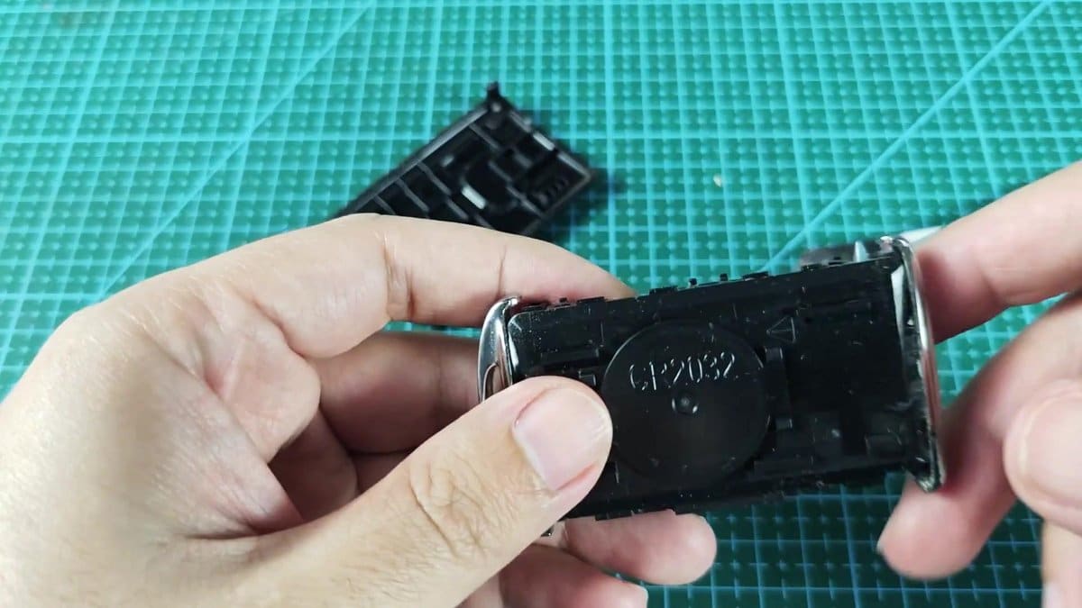 CR2032 battery compartment on green cutting mat