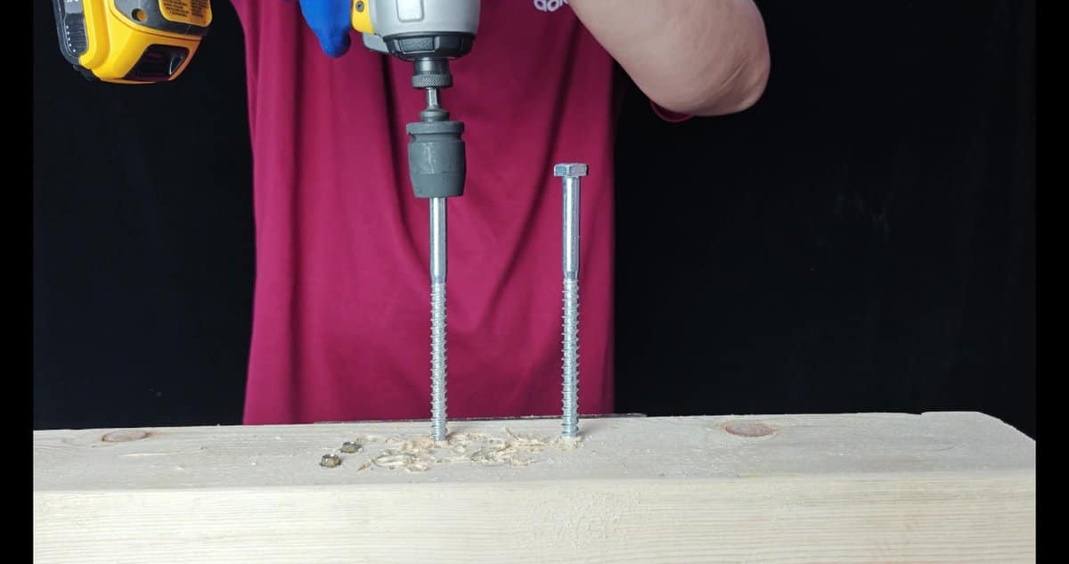 Drill driving screw into wooden plank