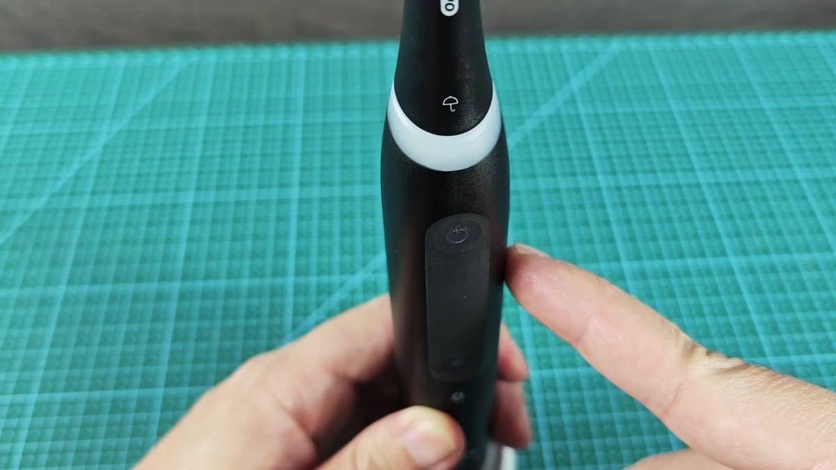 Electric toothbrush with power button visible
