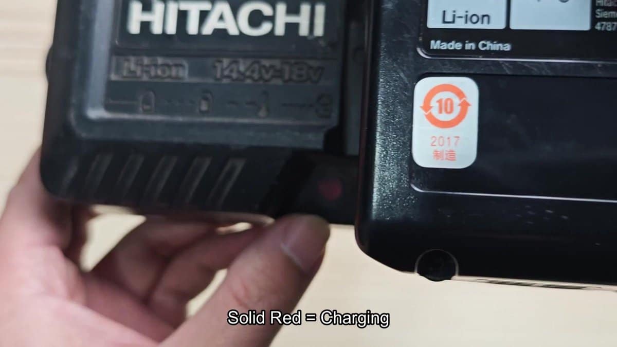 Hitachi battery with charging indicator showing red