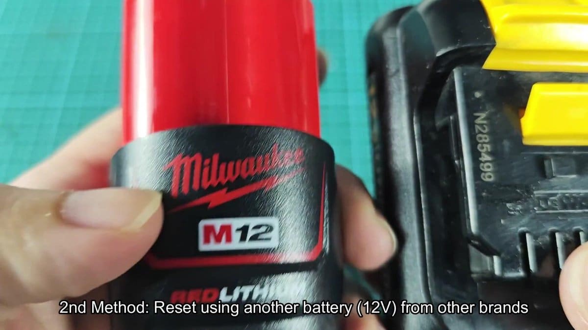 Milwaukee M12 battery held near another battery