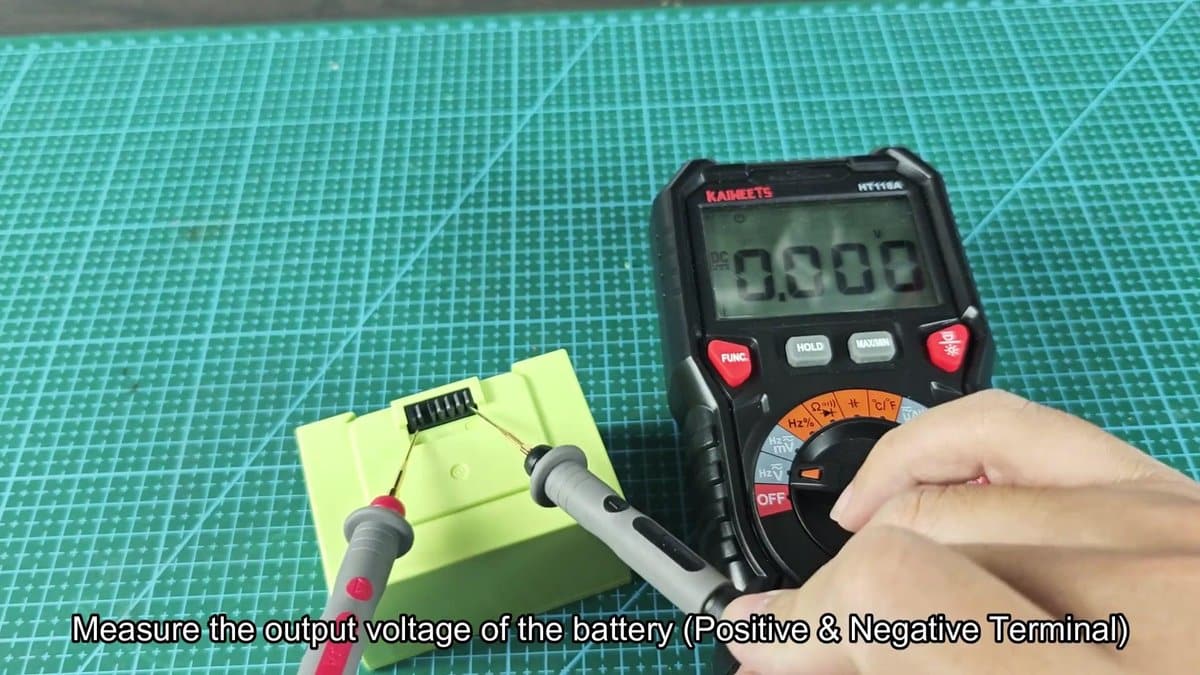 Multimeter measuring voltage on battery terminal
