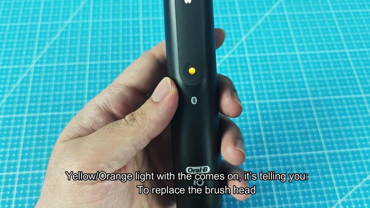 Oral-B iO toothbrush with orange indicator light
