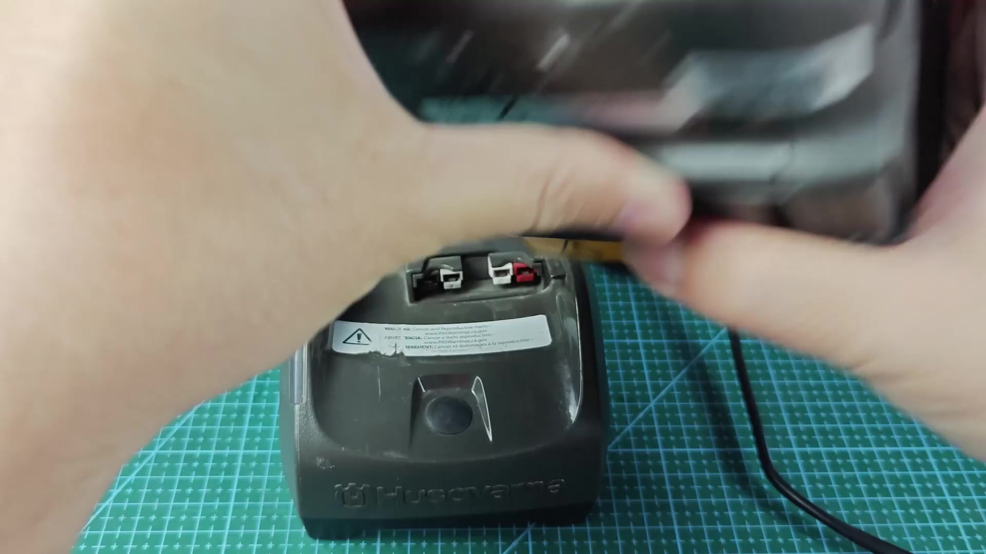 Battery aligning with Husqvarna charger base Battery aligning with Husqvarna charger base