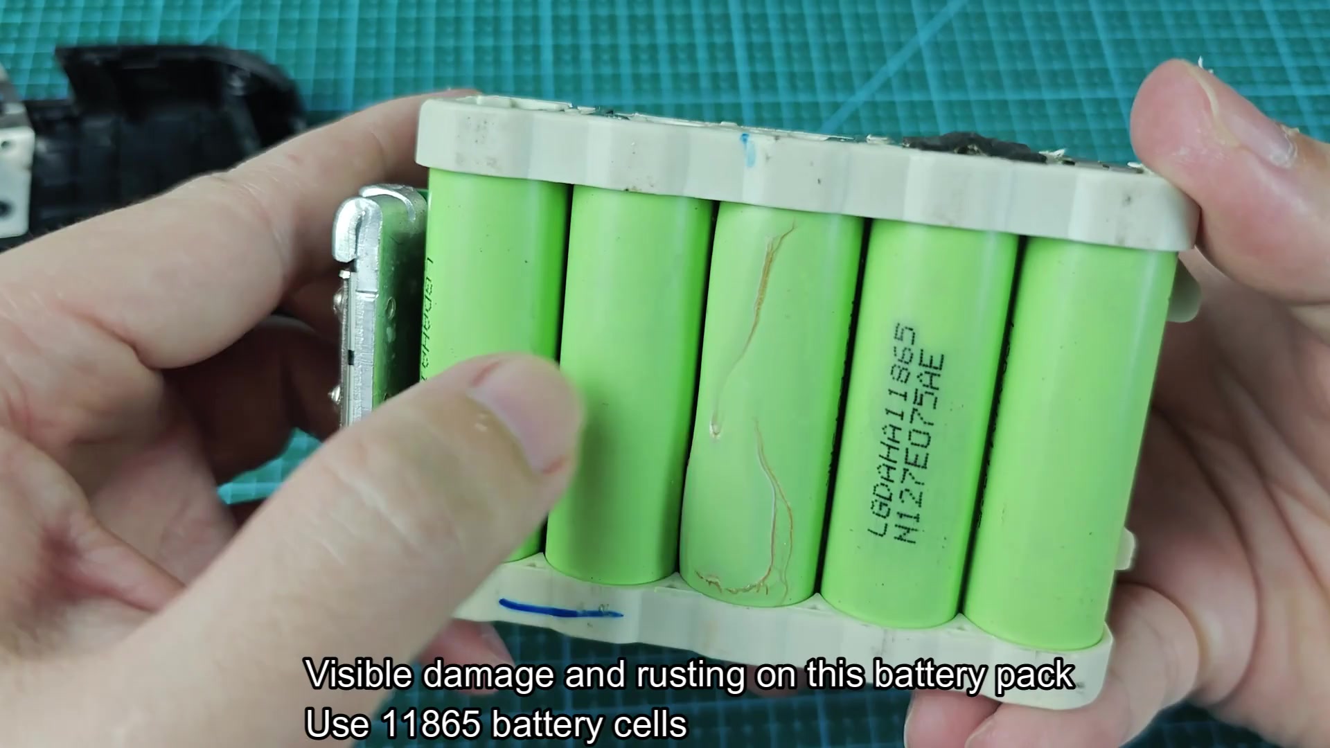 Damaged battery cell with visible dent and rust Damaged battery cell with visible dent and rust
