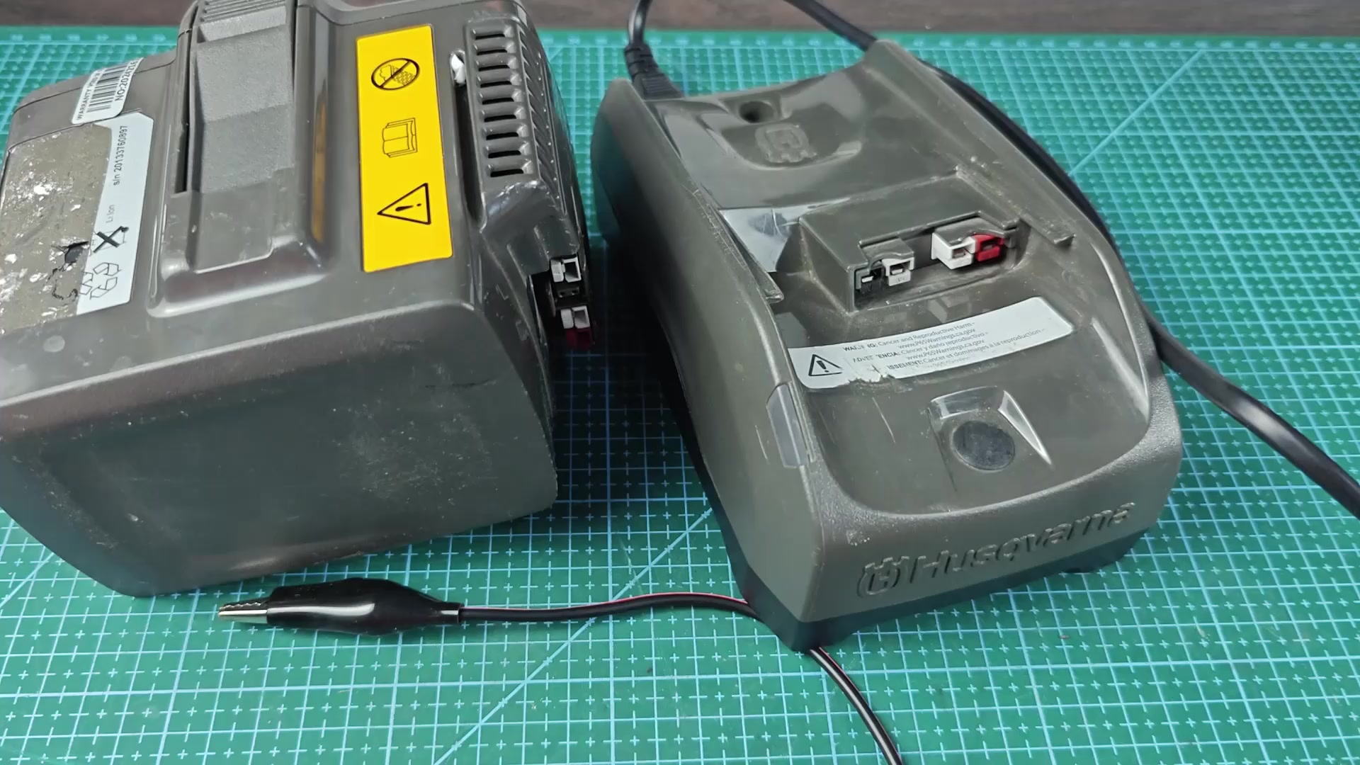 Husqvarna battery next to Husqvarna charger base
