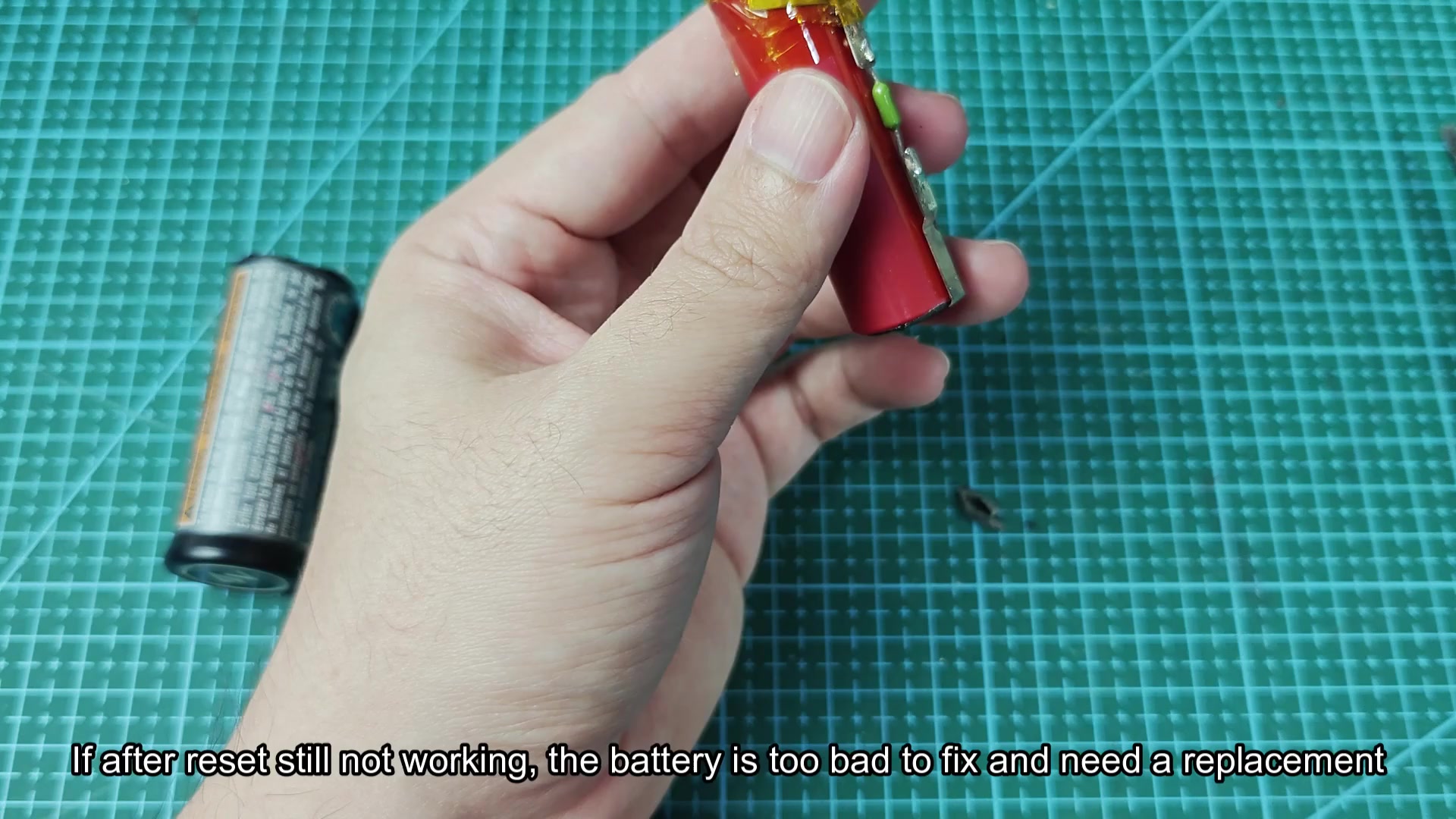 Red opened battery pack beside purple replacement cell