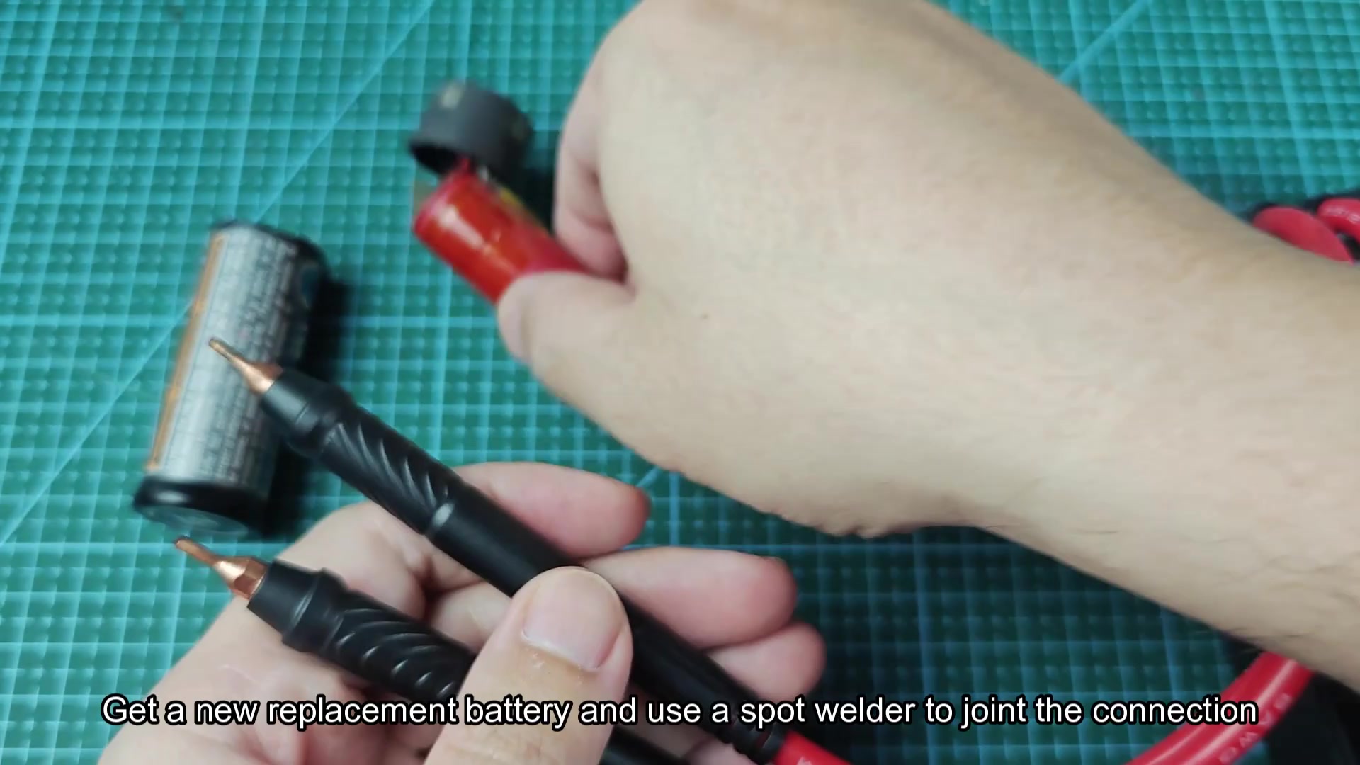 Spot welder probe tip near battery connection point