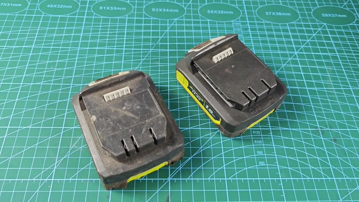 Two worn power tool batteries side by side