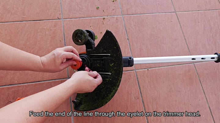 Feed line through trimmer head eyelet Feed line through trimmer head eyelet